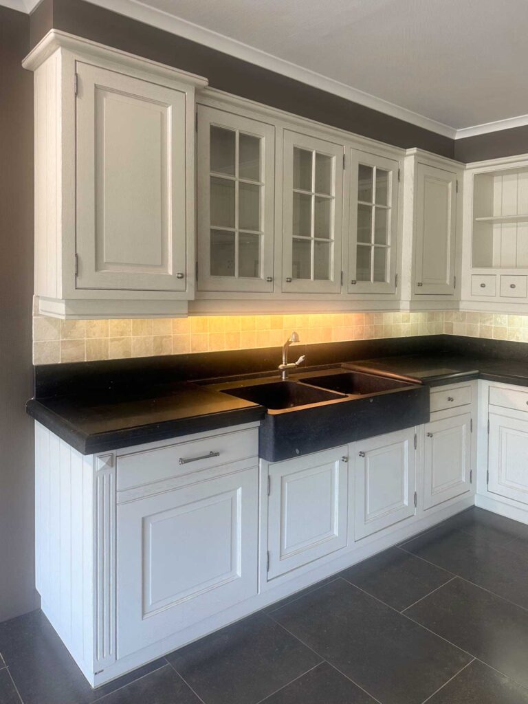 Klassieke-witgelakte-eiken-keuken-met-blauwe-steen-en-volledige-uitrusting